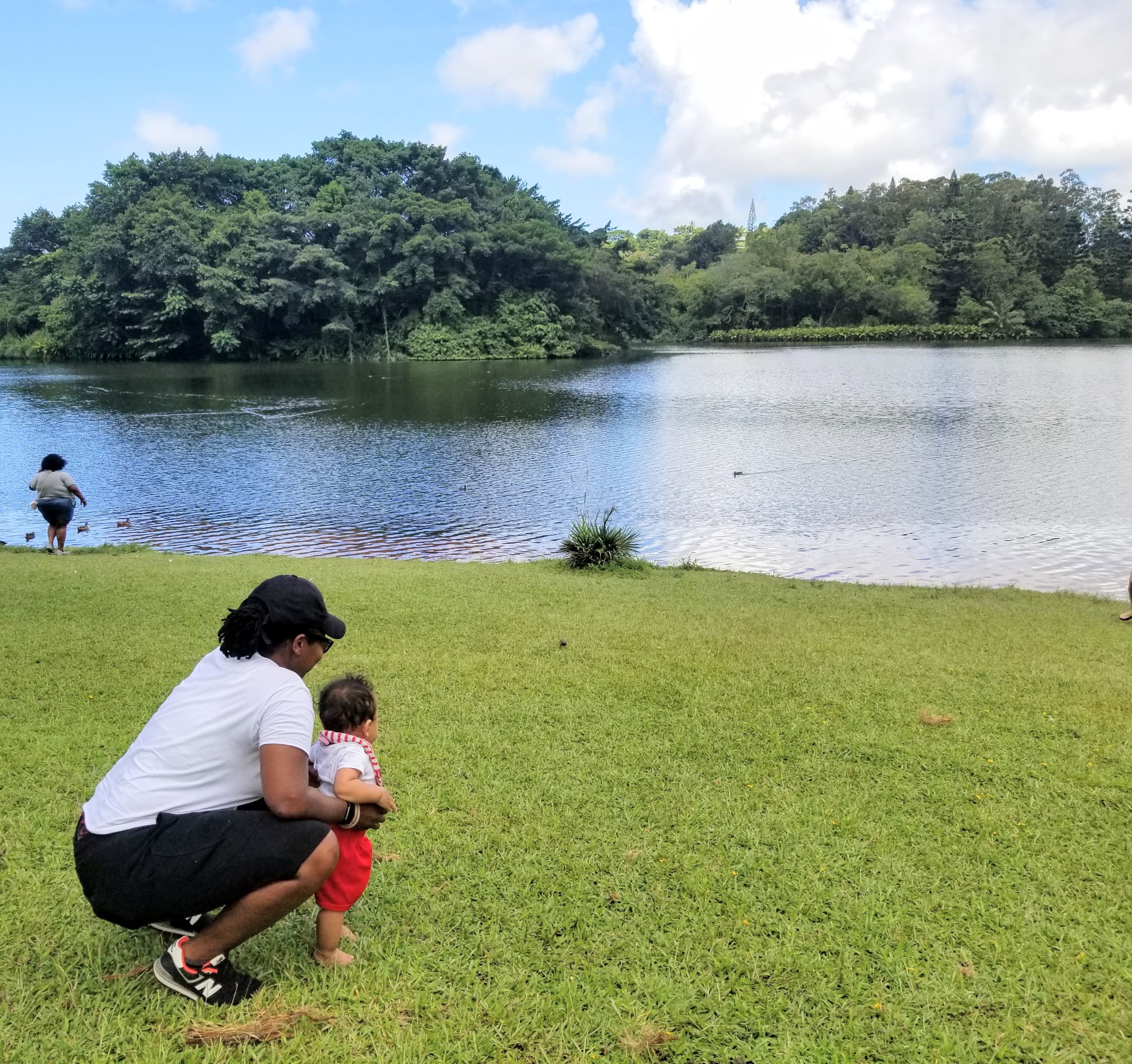woman with baby staring at lake