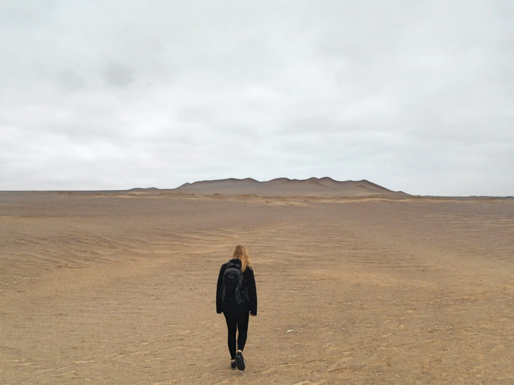 woman walking into desert