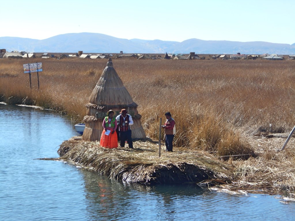 A woman and men on floating islands on lake titicaca