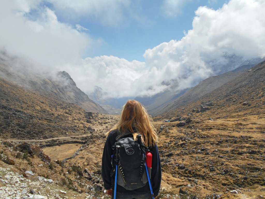 back of woman with backpack staring at unique place to visit in peru - mountains