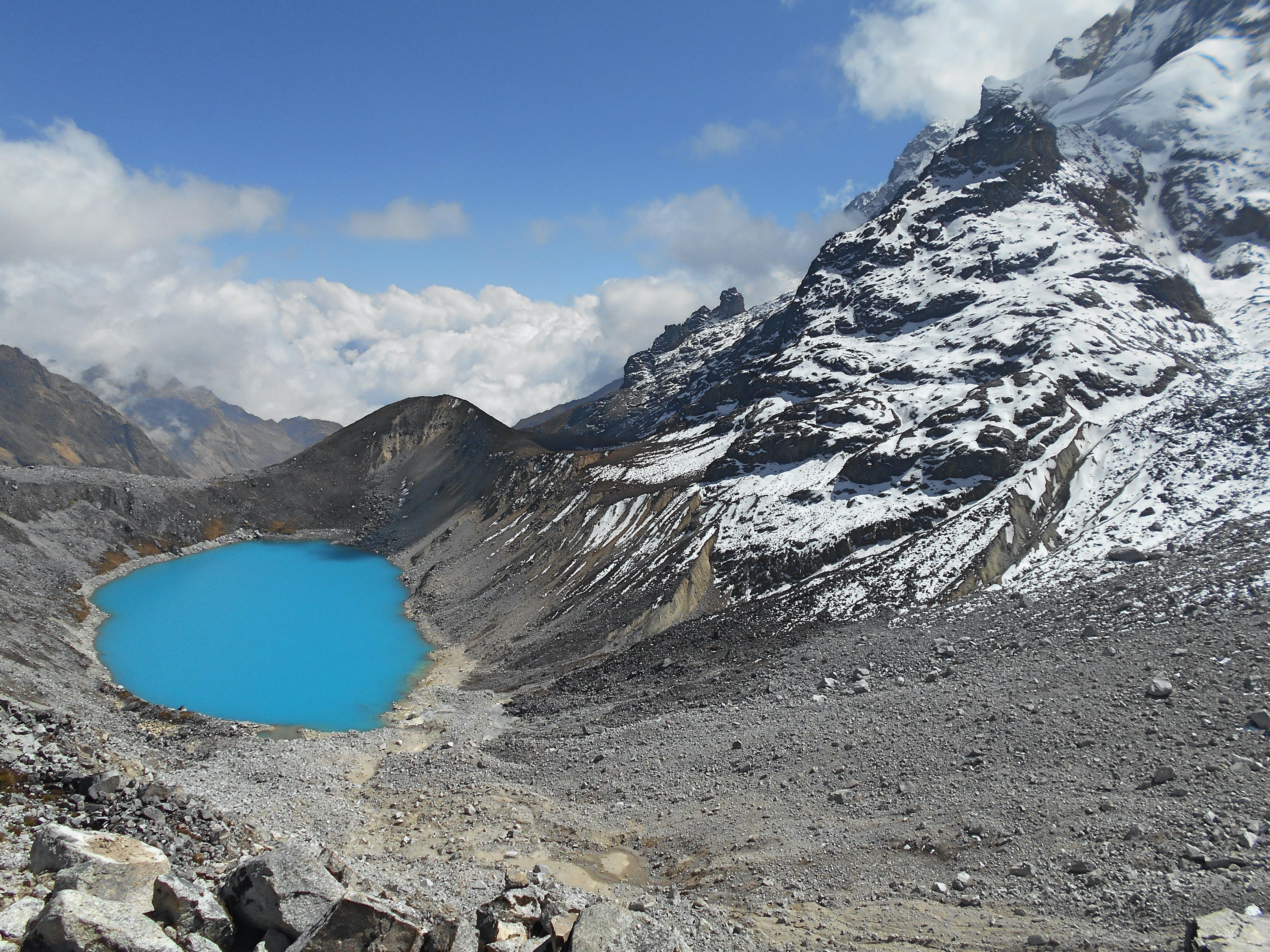 bright blue lake next to snowy mountain